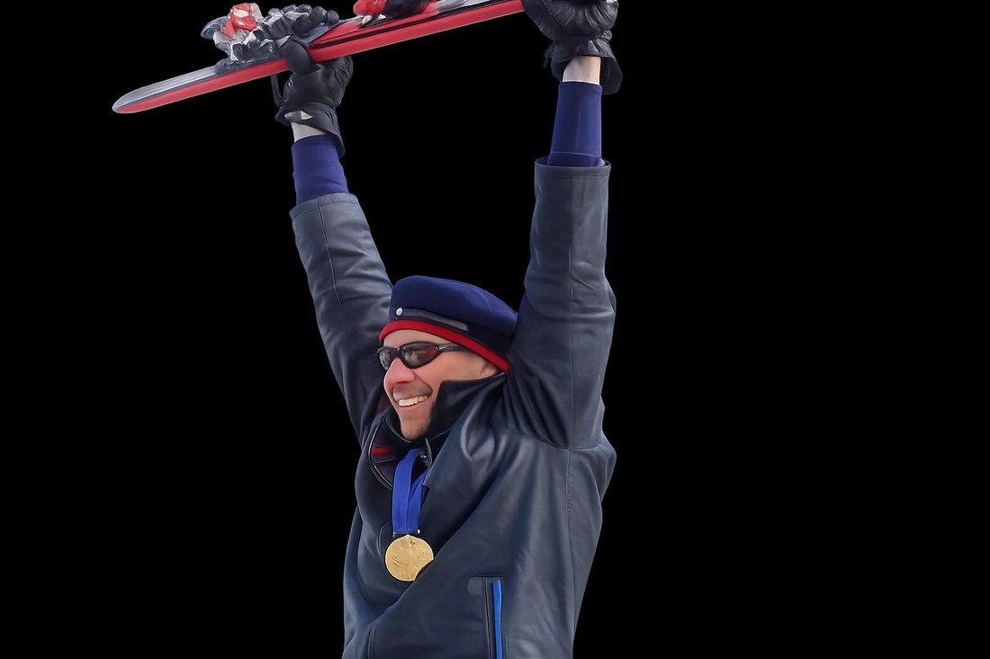 Kevin Bramble, founder of KBGoodZ, hoisting his ski overhead with his Paralympic gold medal